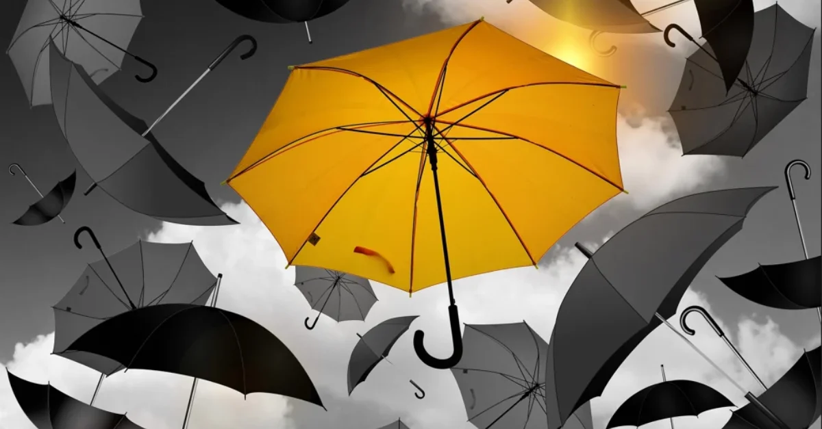 A yellow umbrella is seen flying in the air with other black and grey umbrellas | KASS International